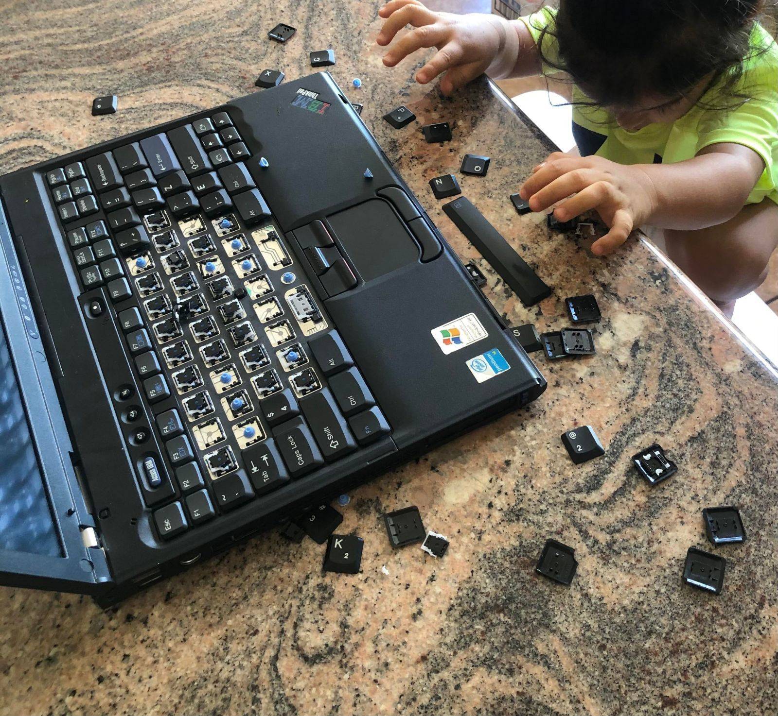 Un enfant retire les touches de l'ordinateur portable